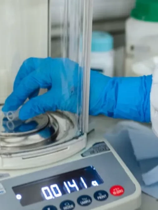 Scientist performing analytical balance calibration in a pharmaceutical quality control laboratory