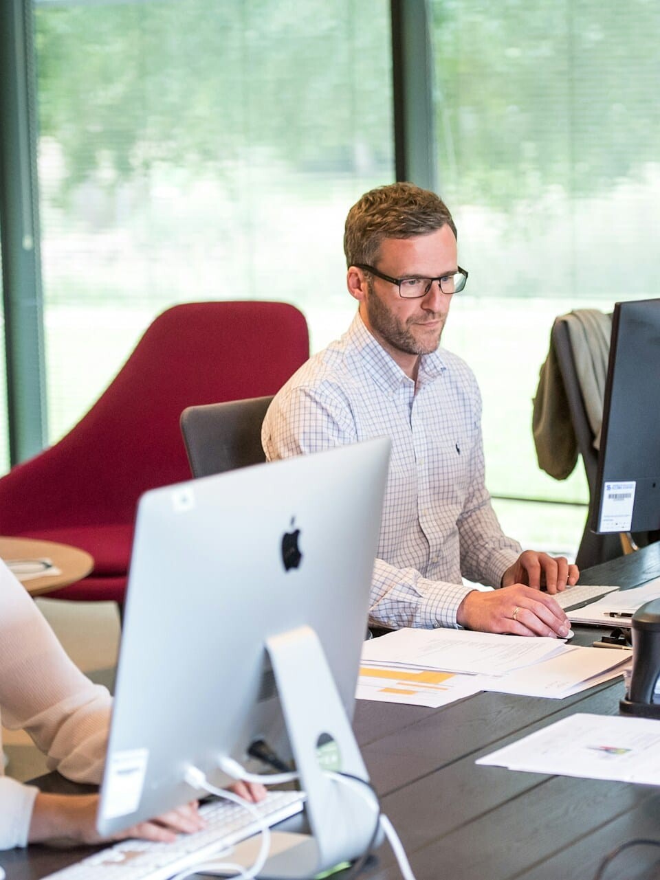 employees working in the office infront of their desks uai