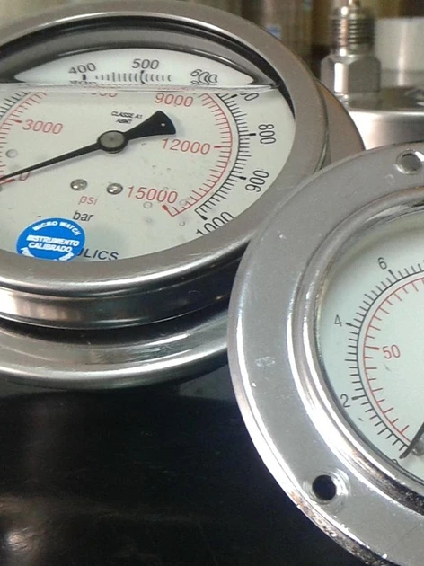 Testing lab vs calibration lab — calibrated pressure gauges with accredited calibration stickers on a lab bench.