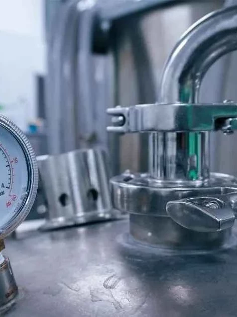 An analog pressure gauge on industrial equipment, the kind of instrument teams calibrate test equipment on regularly to catch drift