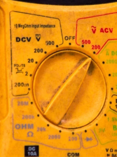Technician holding a multimeter in the field, the kind of calibration gaps a due diligence audit is meant to catch