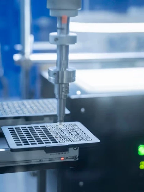 A robotic arm performing precision automated lab work, representing calibration recordkeeping in modern testing environments